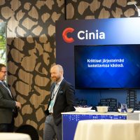 Messutunnelmaa Valtio Expon näyttelyalueella. Kaksi ihmistä keskustelemassa Cinian messuosastolla.